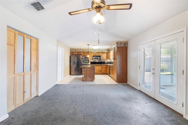 429 Bertolino Dr, Kenner, LA 70065 - kitchen with brown cabinetry, french doors, stainless steel appliances, light colored carpet, and visible vents