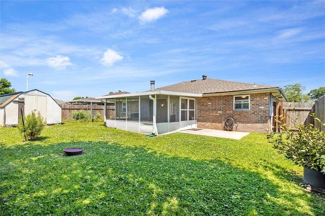 429 Bertolino Dr, Kenner, LA 70065 - rear view of property featuring a fenced backyard, a storage shed, a patio area, brick siding, and a sunroom