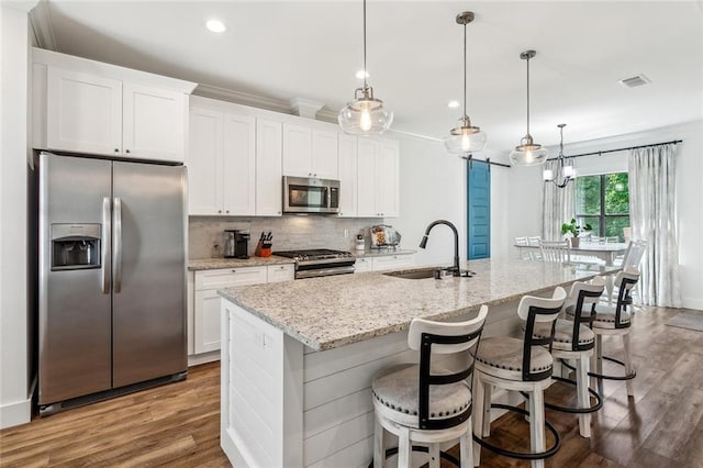 kitchen with visible vents, a sink, decorative backsplash, appliances with stainless steel finishes, and white cabinetry