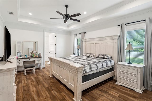 bedroom featuring a tray ceiling, visible vents, crown molding, and dark wood-style flooring