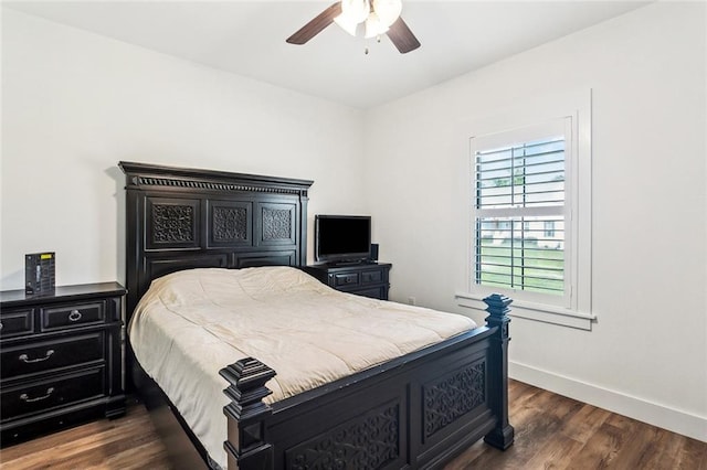 bedroom with dark wood finished floors, a ceiling fan, and baseboards