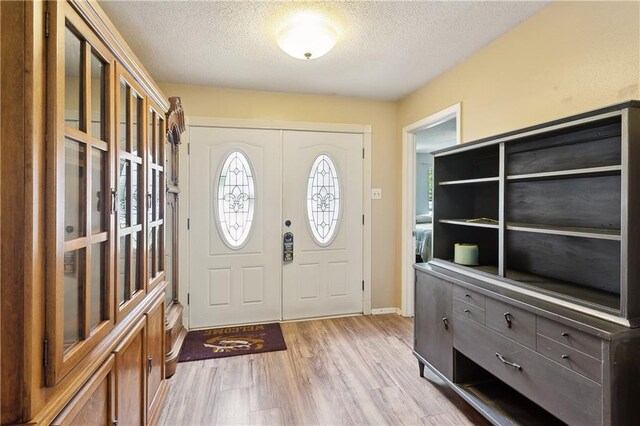 123 Robinhood Rd, Covington, LA 70433 - entryway featuring baseboards, light wood-style flooring, and a textured ceiling