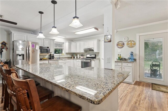 123 Robinhood Rd, Covington, LA 70433 - kitchen featuring ornamental molding, under cabinet range hood, and stainless steel appliances