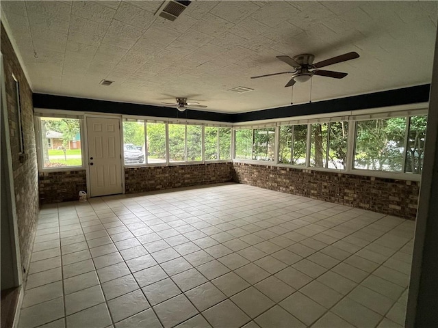 123 Robinhood Rd, Covington, LA 70433 - unfurnished sunroom featuring a ceiling fan, brick wall, and tile patterned flooring