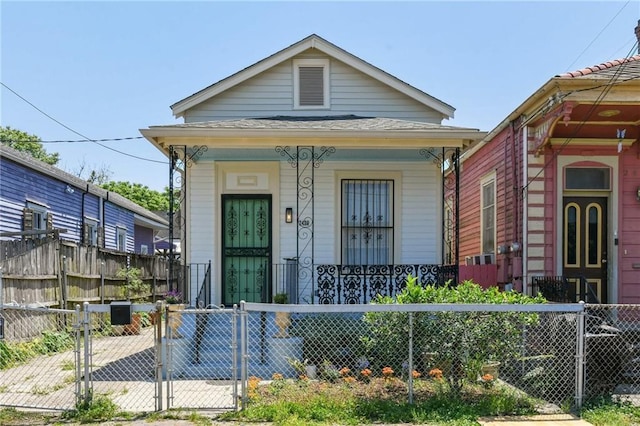 2426 Chippewa St, New Orleans, LA 70130 - shotgun-style home featuring a gate, covered porch, and a fenced front yard