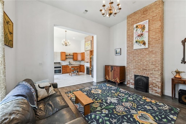 2426 Chippewa St, New Orleans, LA 70130 - living area featuring a chandelier, wood finished floors, a towering ceiling, and baseboards