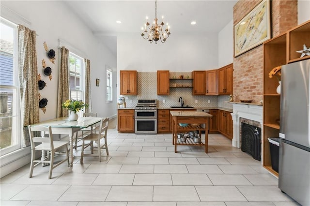 2426 Chippewa St, New Orleans, LA 70130 - kitchen with open shelves, appliances with stainless steel finishes, a high ceiling, brown cabinetry, and a chandelier