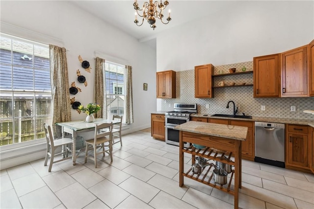 2426 Chippewa St, New Orleans, LA 70130 - kitchen with appliances with stainless steel finishes, open shelves, a chandelier, brown cabinets, and a high ceiling