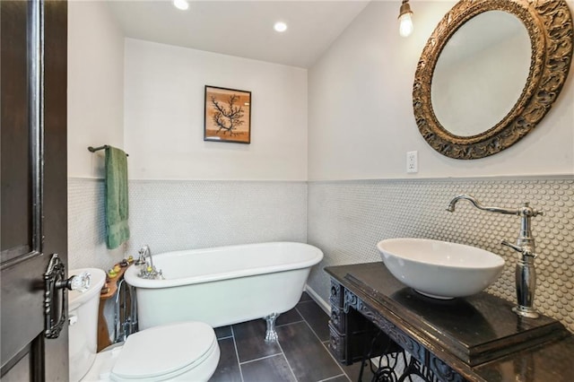 2426 Chippewa St, New Orleans, LA 70130 - bathroom featuring a soaking tub, toilet, wainscoting, tile walls, and recessed lighting