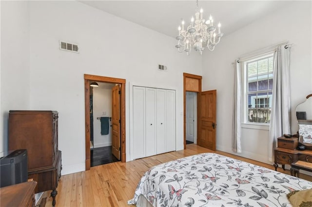 2426 Chippewa St, New Orleans, LA 70130 - bedroom featuring a chandelier, light wood-style floors, baseboards, a high ceiling, and a closet