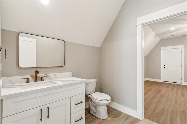 bathroom featuring vaulted ceiling, wood finished floors, toilet, and vanity