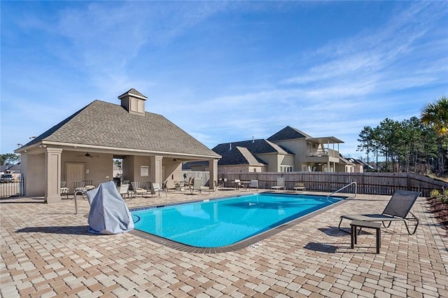 community pool featuring a fenced backyard, a patio area, and a ceiling fan