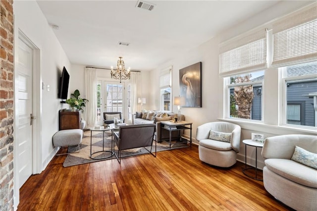 370507 Laurel St, New Orleans, LA 70115 - living area with wood-type flooring, visible vents, baseboards, and a notable chandelier