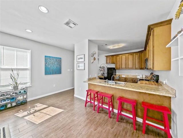 2738 Cleveland Ave, New Orleans, LA 70119 - kitchen with electric range, brown cabinetry, wood finished floors, and visible vents