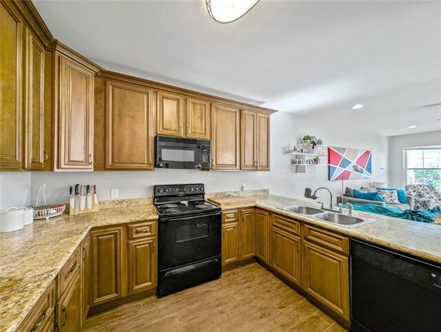 2738 Cleveland Ave, New Orleans, LA 70119 - kitchen with a sink, black appliances, brown cabinets, light wood-style floors, and light stone countertops