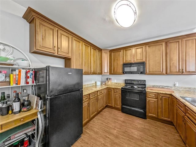 2738 Cleveland Ave, New Orleans, LA 70119 - kitchen with black appliances, brown cabinets, and light wood-type flooring
