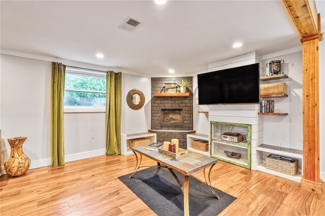 living area with light wood-style flooring, baseboards, visible vents, recessed lighting, and a fireplace