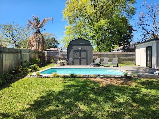 view of pool with a lawn, a fenced backyard, a storage unit, and an outdoor structure