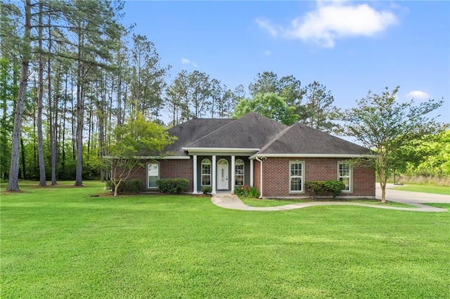 ranch-style home featuring brick siding, roof with shingles, and a front yard