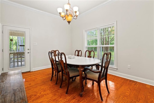 dining space with an inviting chandelier, baseboards, plenty of natural light, and crown molding