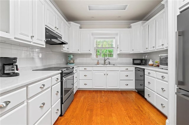 kitchen featuring light countertops, a sink, black appliances, under cabinet range hood, and white cabinetry