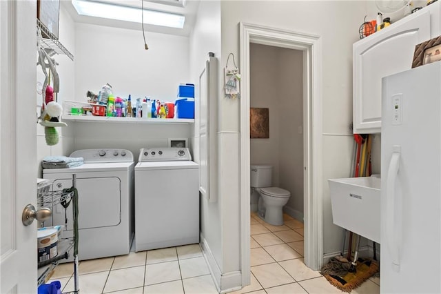 washroom with laundry area, a sink, washing machine and dryer, and light tile patterned floors