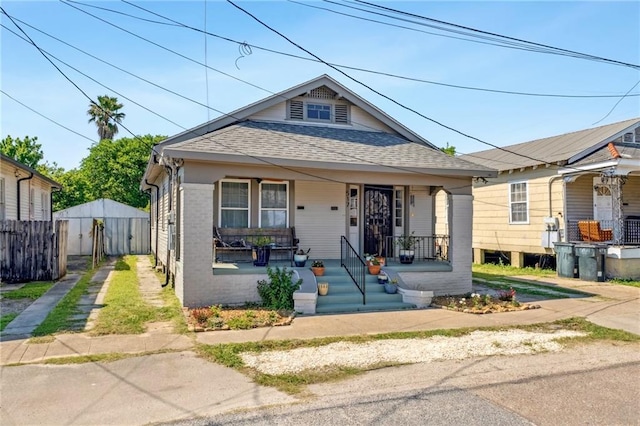 517 S Murat St, New Orleans, LA 70119 - view of front of home with a shingled roof, a porch, and brick siding