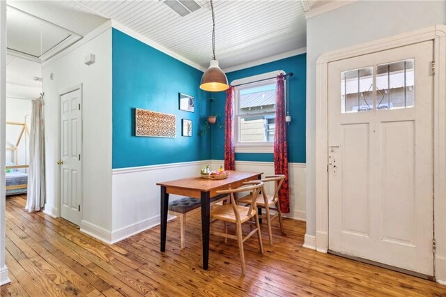 517 S Murat St, New Orleans, LA 70119 - dining room featuring attic access, wood-type flooring, wainscoting, and crown molding