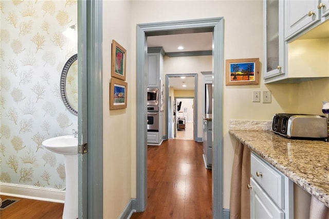 3439 Octavia St, New Orleans, LA 70125 - hall featuring dark wood-type flooring, visible vents, a toaster, baseboards, and wallpapered walls