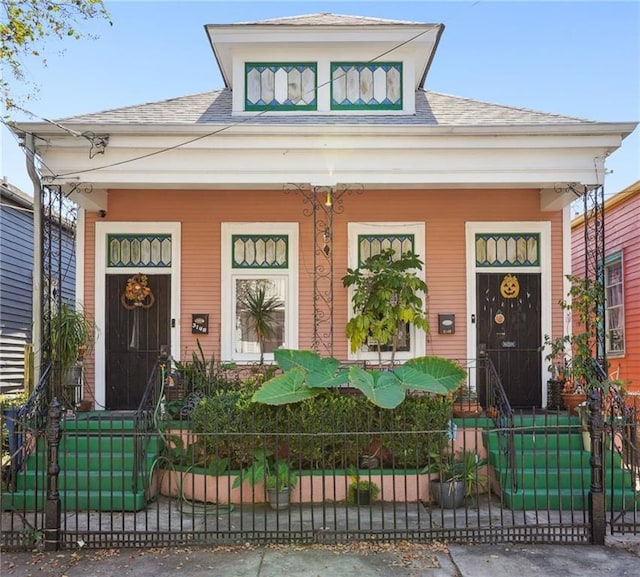 view of front of home featuring a porch, fence private yard, and roof with shingles