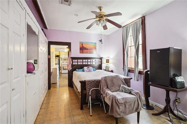 bedroom featuring tile patterned floors, visible vents, and ceiling fan