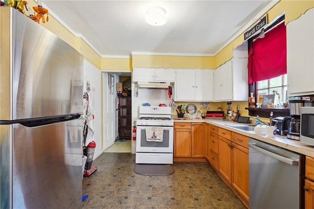 kitchen with ornamental molding, light countertops, under cabinet range hood, and appliances with stainless steel finishes