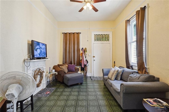 living room featuring ceiling fan and dark floors