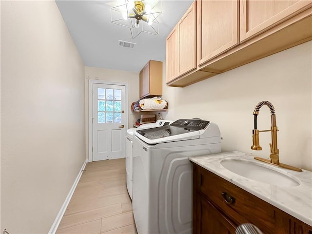 laundry room featuring cabinet space, washer and dryer, baseboards, and light wood-style floors