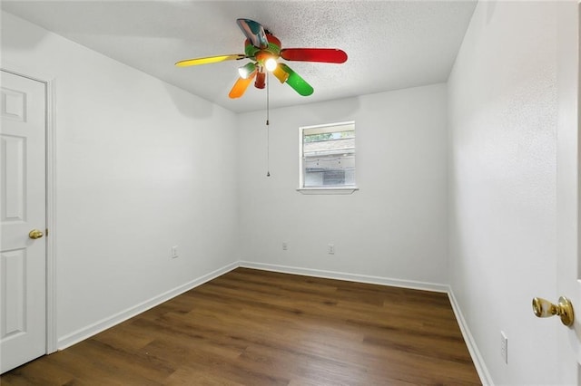 spare room featuring ceiling fan, baseboards, wood finished floors, and a textured ceiling
