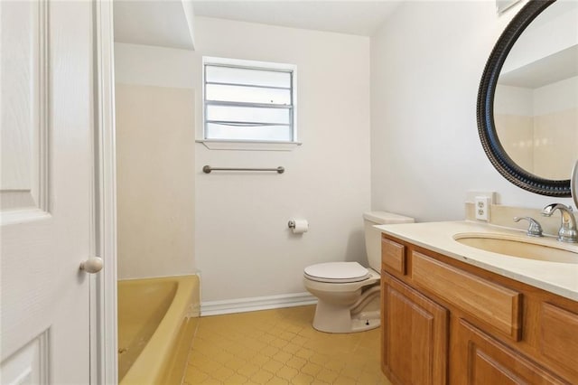 bathroom with a tub to relax in, baseboards, vanity, and toilet