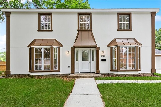 3810 Tall Pines Dr, New Orleans, LA 70131 - view of front of property featuring stucco siding, concrete driveway, a shingled roof, a standing seam roof, and metal roof