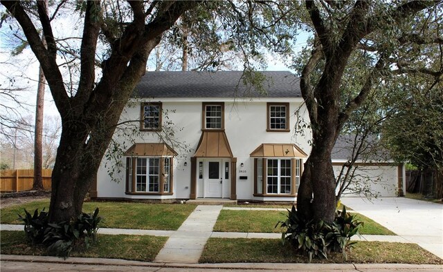 3810 Tall Pines Dr, New Orleans, LA 70131 - view of front of property featuring concrete driveway, stucco siding, a front lawn, and a shingled roof