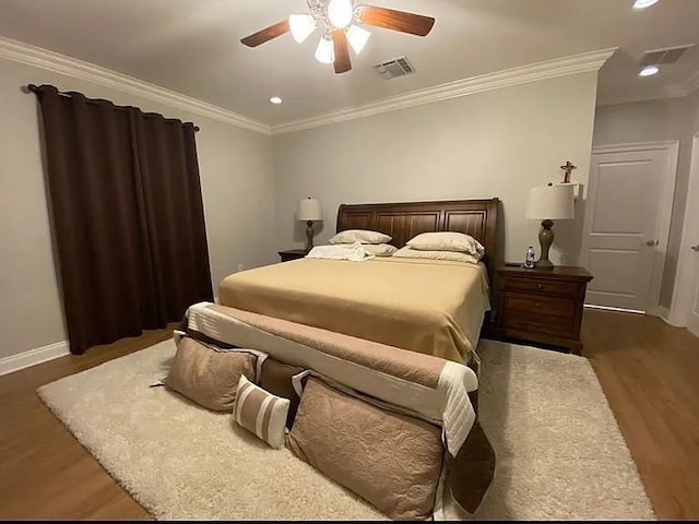bedroom featuring baseboards, ornamental molding, and wood finished floors