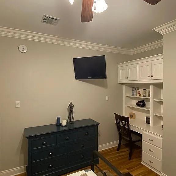 home office with visible vents, ornamental molding, baseboards, and ceiling fan