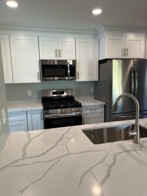 42 Boimare Ave, Kenner, LA 70065 - kitchen with appliances with stainless steel finishes, white cabinets, a sink, recessed lighting, and light stone counters