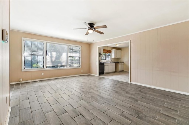 8936 Curran Blvd, New Orleans, LA 70127 - unfurnished living room featuring wood tiled floor, baseboards, ceiling fan, and crown molding