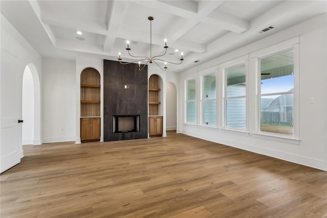 1161 Audubon Pkwy, Madisonville, LA 70447 - unfurnished living room with arched walkways, light wood-type flooring, baseboards, coffered ceiling, and a large fireplace