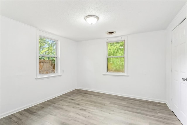 1279 Jaycee Dr, Slidell, LA 70460 - empty room with plenty of natural light, light wood-style flooring, a textured ceiling, and baseboards