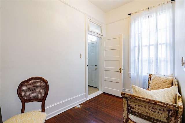 sitting room featuring baseboards and dark wood-type flooring