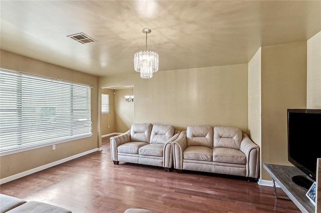 4901 Coronado Dr, New Orleans, LA 70127 - living room featuring dark wood finished floors, an inviting chandelier, visible vents, and baseboards