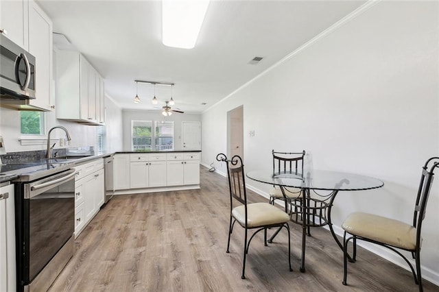 131 Hickory St, Reserve, LA 70084 - kitchen with dark countertops, a sink, stainless steel appliances, a peninsula, and ornamental molding