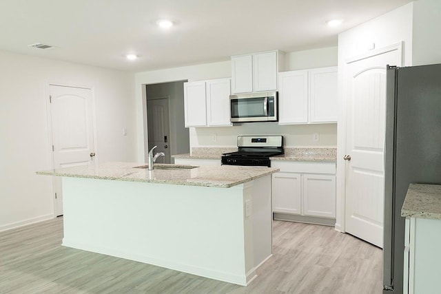 40495 Cara Mae St, Slidell, LA 70461 - kitchen with a sink, white cabinets, light wood finished floors, stainless steel appliances, and an island with sink