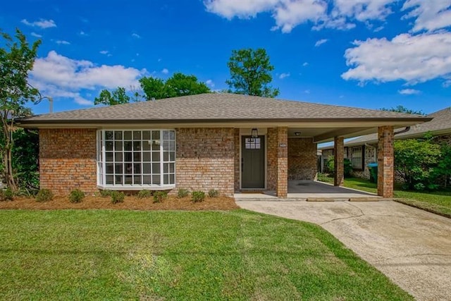 single story home featuring an attached carport, brick siding, driveway, and a front lawn