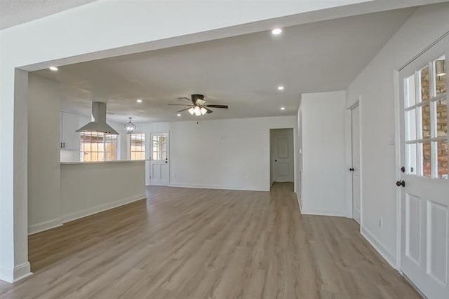 unfurnished living room with baseboards, a ceiling fan, recessed lighting, and light wood-style flooring